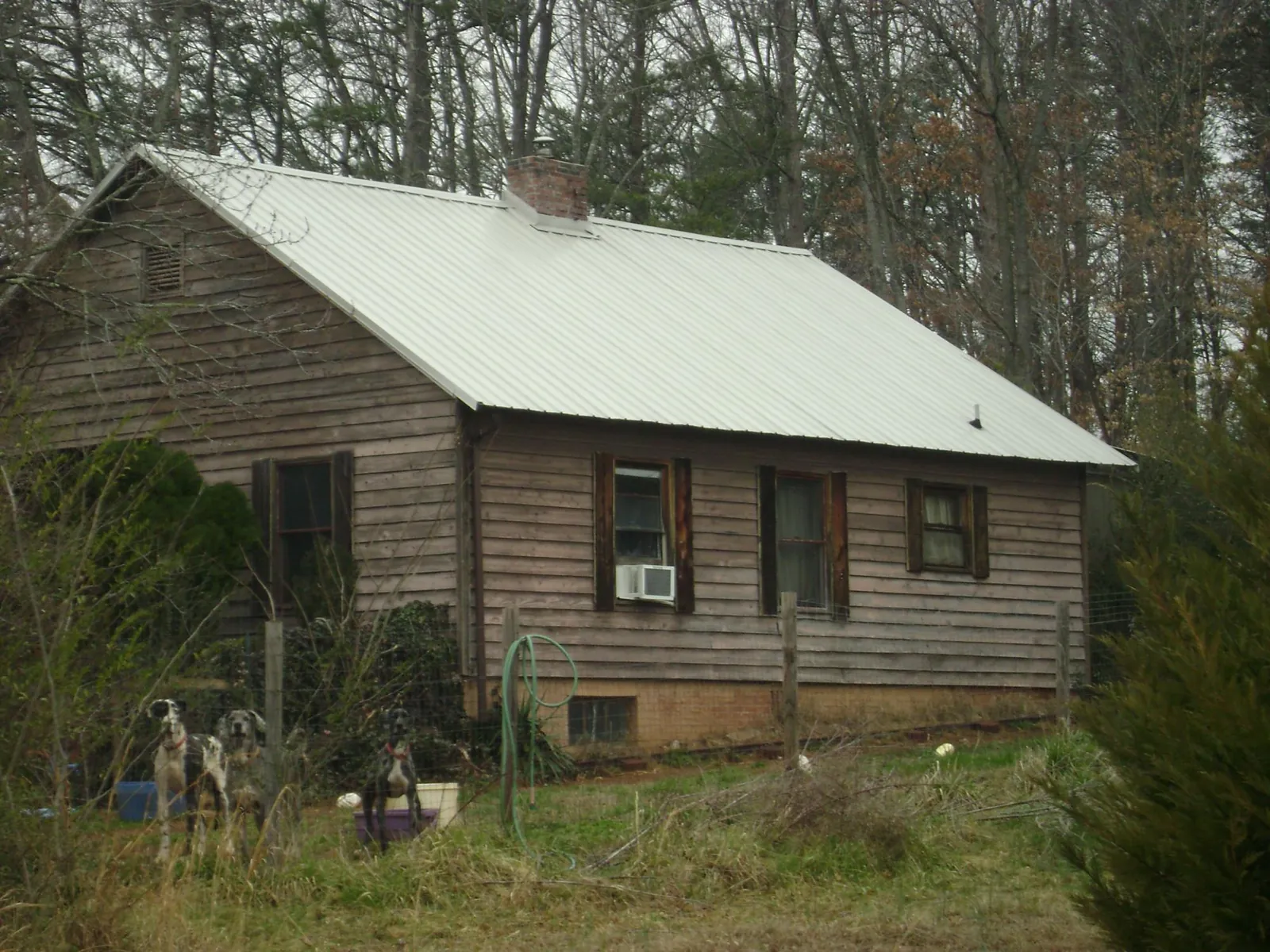 White metal roof on an old wood sided farmhouse, from a Metal Roof Installation job in Rockville